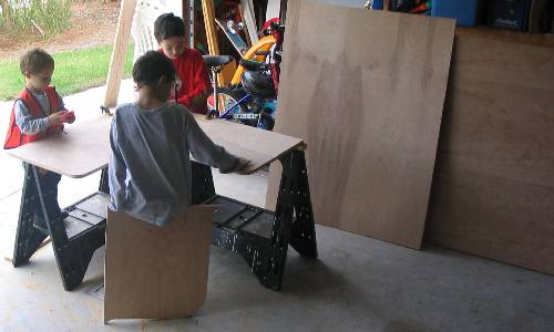 Sons helping with cutting the plywood.
