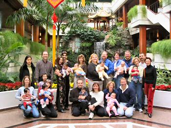 9 families in front of an indoor waterfall at the White Swan Hotel