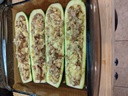 Place the zucchini halves into a baking dish and then fill with the mixture.